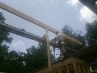 Carpenter setting a ridge beam over a new addition frame — Ice Dam Removal by Roofing Brothers in Arcola