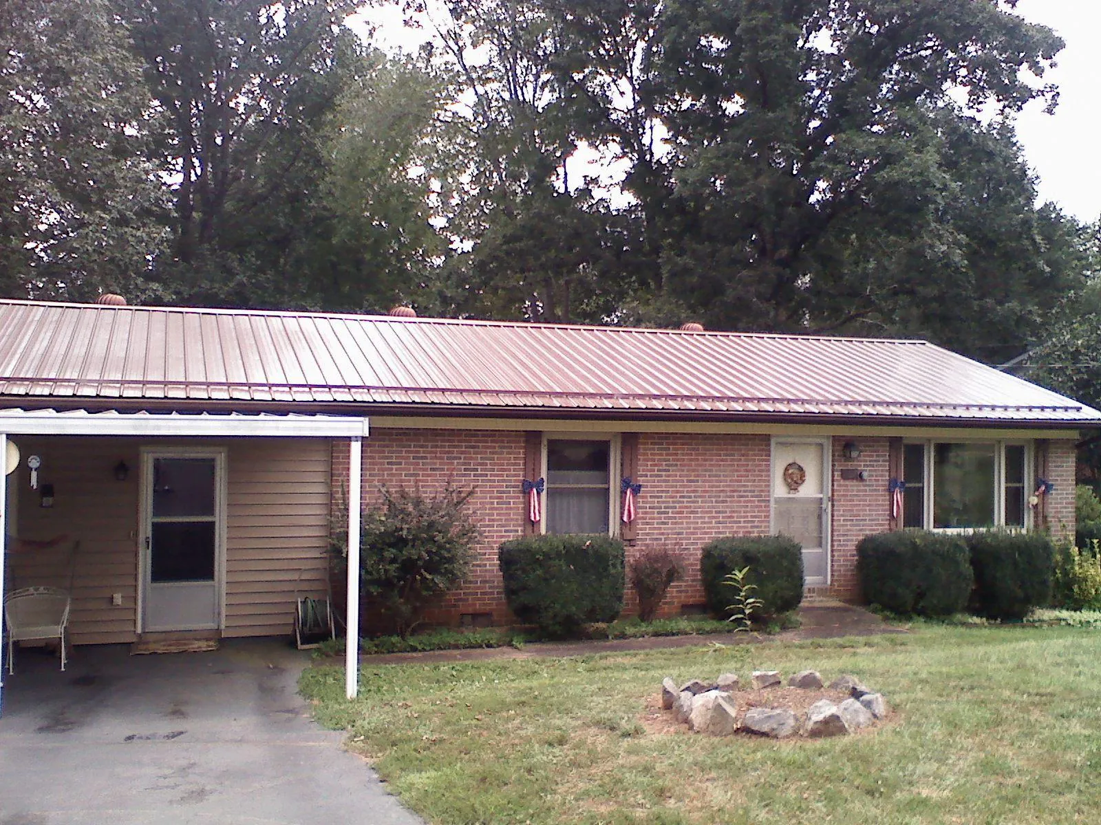 Bronze metal roof and carport on a brick ranch home — Roof Repair work by our crew in Arcola